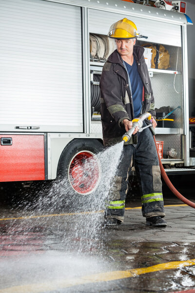 Fireman Spraying Water On Floor During Practice