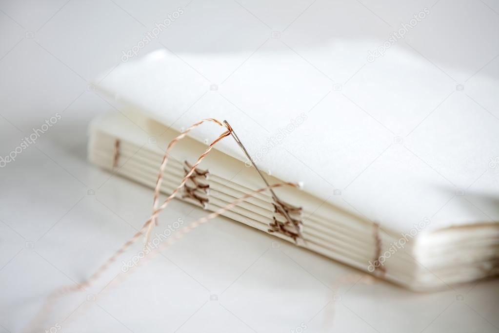 Needle And Notepad Papers On Table