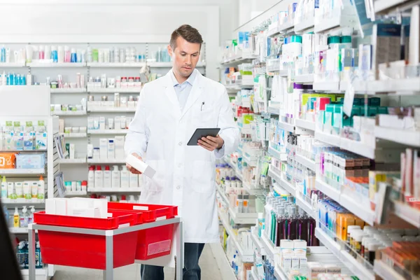 Homme pharmacien mise à jour stock en tablette numérique — Photo