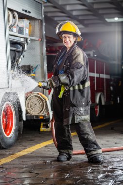 Mutlu Firewoman antrenman sırasında su püskürtme