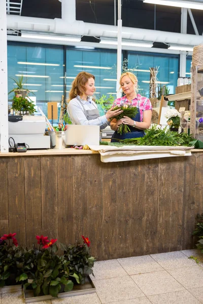 Floristas fazendo buquê na loja de flores — Fotografia de Stock