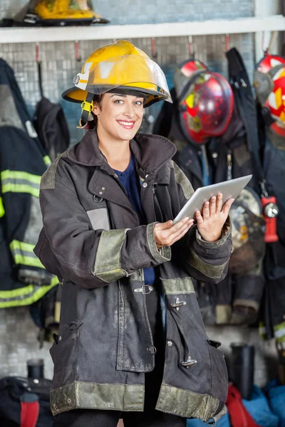 Bombeiro feliz segurando tablet digital no quartel de bombeiros — Fotografia de Stock