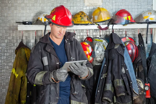 Brandweerman met behulp van digitale Tablet op brandweerkazerne — Stockfoto