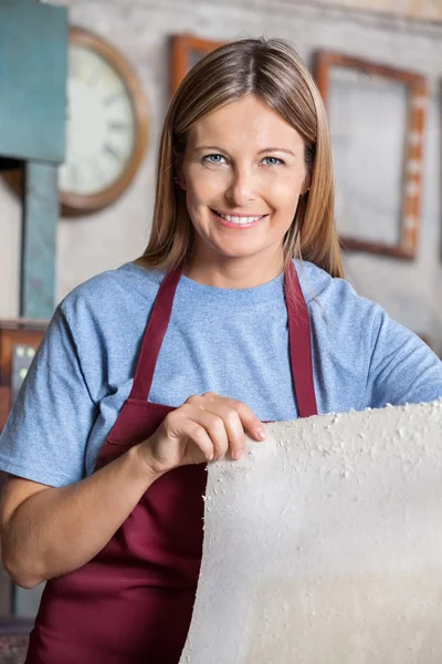 Feminino trabalhador segurando folha de papel na fábrica — Fotografia de Stock