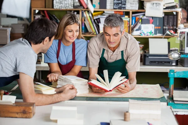 Trabajadores analizando cuaderno juntos en fábrica — Foto de Stock