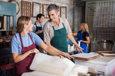 Mutlu işçiler birbirlerine bakarken kağıtları yapma