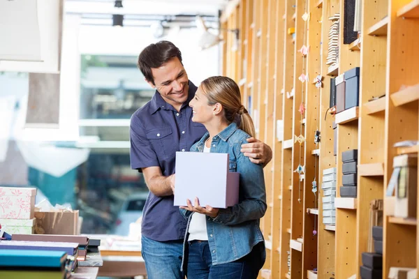 Vrouw doos van de Gift houden terwijl op zoek naar Man In winkel — Stockfoto