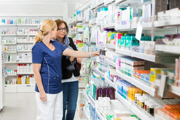 Farmacêutico removendo o produto para o cliente da prateleira — Fotografia de Stock