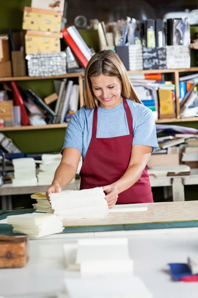 Mulher empilhando papéis na mesa na fábrica — Fotografia de Stock