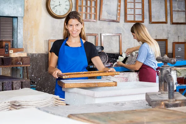 Lavoratori sorridenti che fanno carte in fabbrica — Foto Stock