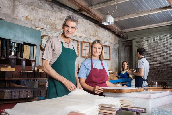 Kendine güvenen erkek ve kadın kağıtları fabrikada yapım — Stok fotoğraf