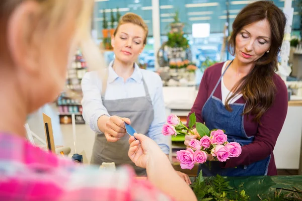 Florister sälja ros bukett till kund i butik — Stockfoto