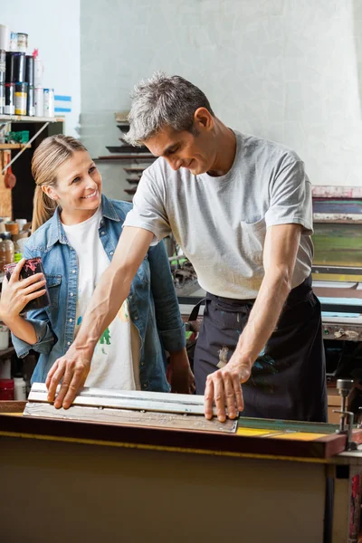 Trabalhador olhando para masculino Colega usando Squeegee — Fotografia de Stock