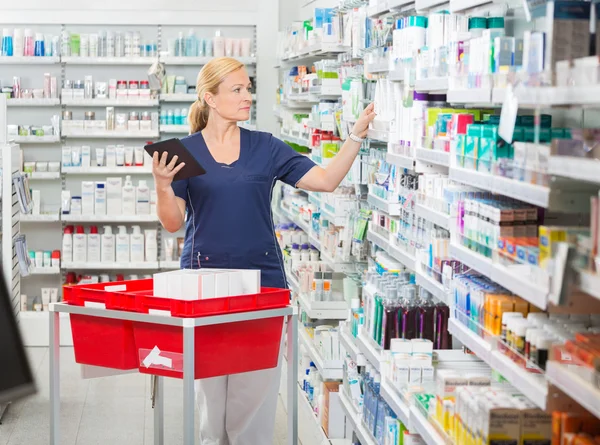 Farmacéutica femenina Actualización de stock en tabletas digitales —  Fotos de Stock