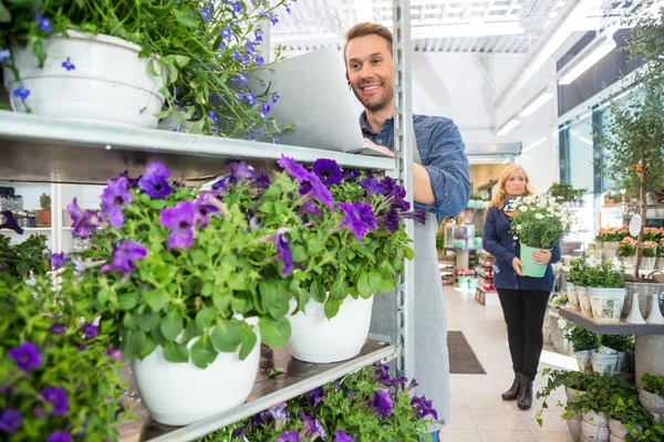 Owner Using Mobile Phone And Laptop In Flower Shop — Stock Photo, Image