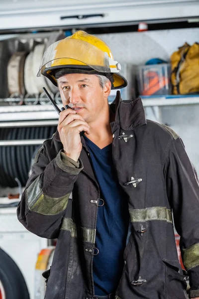 Brandweerman met behulp van Walkie Talkie op brandweerkazerne — Stockfoto