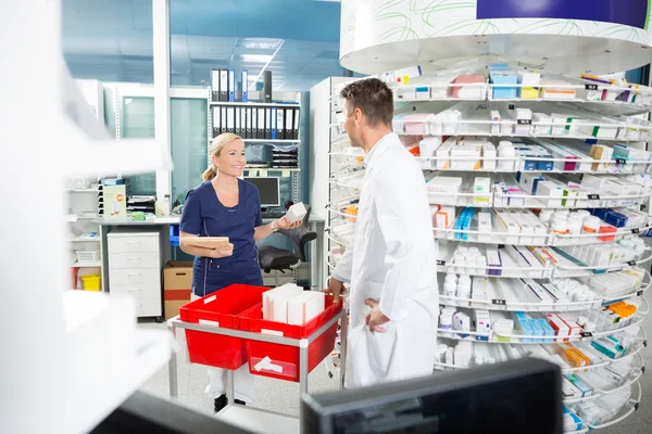 Farmacéutico y asistente contando acciones en farmacia — Foto de Stock