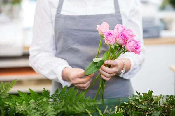 Florista fazendo buquê de rosas na loja de flores — Fotografia de Stock