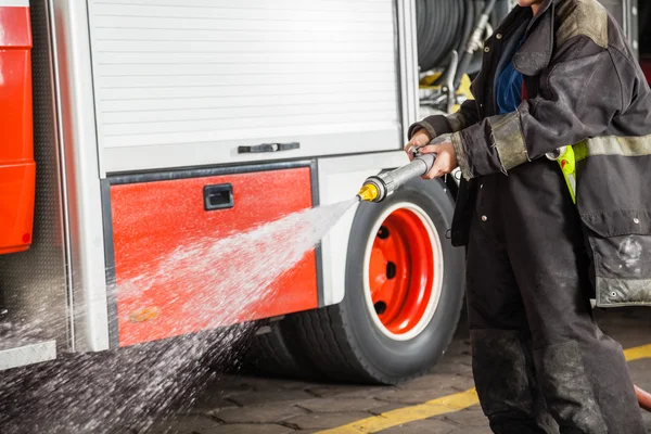 Firewoman spruzzare acqua durante la formazione — Foto Stock