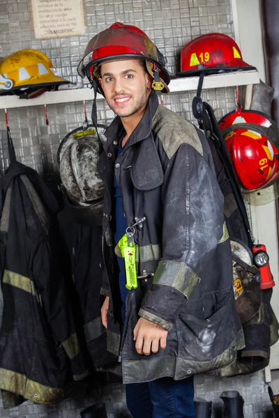 Bombeiro sorridente de uniforme no quartel de bombeiros — Fotografia de Stock