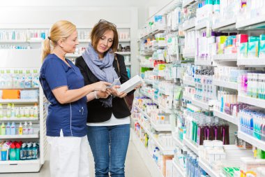 Kadın alıcıya ürün ayrıntıları açıklayan kimyager