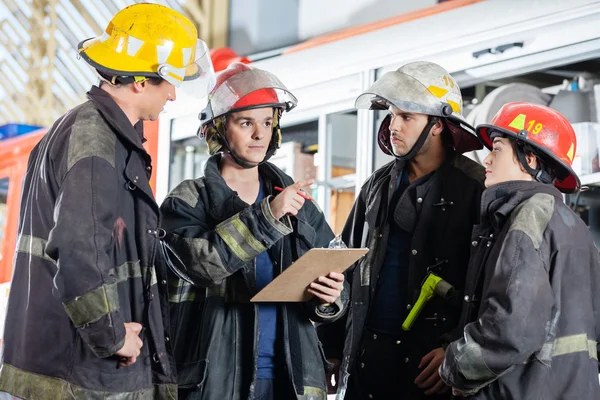 Feuerwehrmann gestikuliert im Gespräch mit Kollegen — Stockfoto