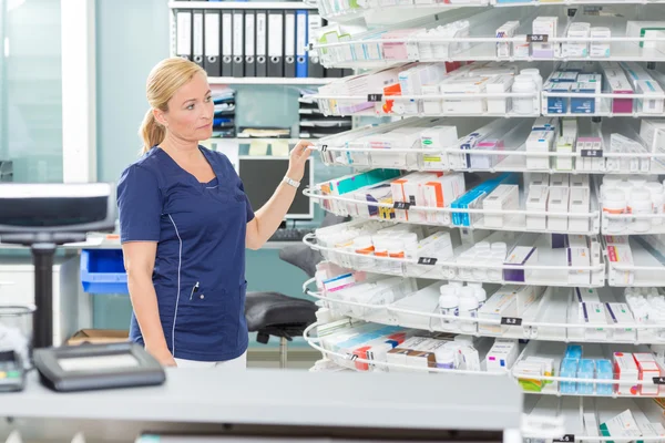 Química femenina mirando productos en farmacia —  Fotos de Stock