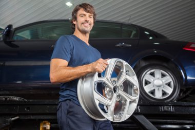 Gülümseyen teknisyen alaşım tamir dükkanında Holding