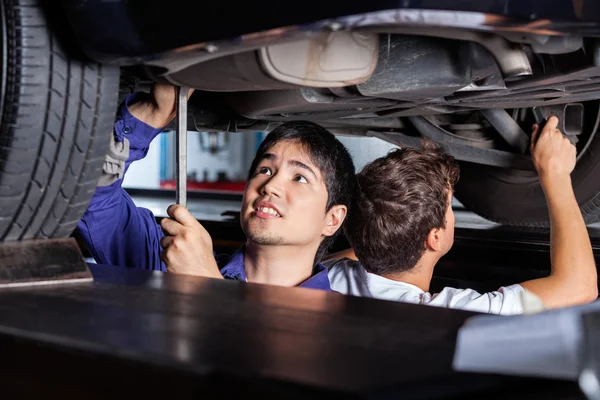 Mecánica trabajando debajo del coche —  Fotos de Stock