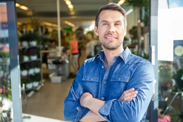 Zelfverzekerde Man permanent buiten bloemenwinkel — Stockfoto