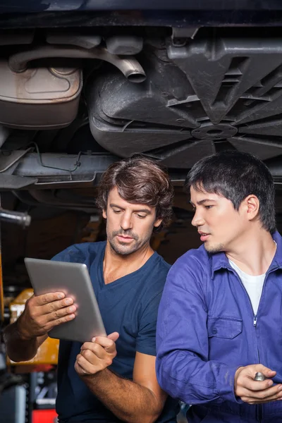 Mechanics Using Digital Tablet Under Lifted Car — Stock Photo, Image