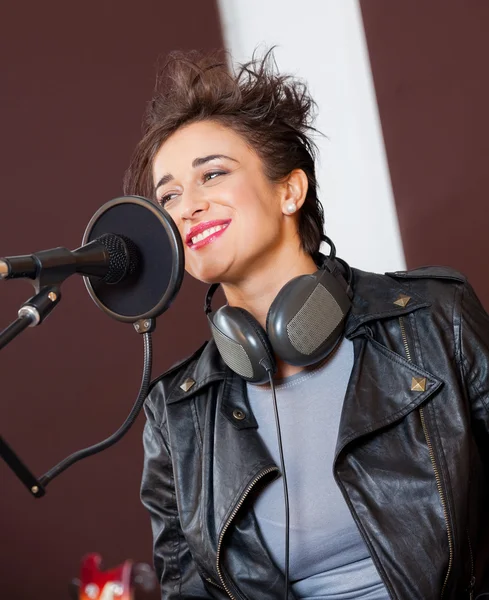 Усміхнена жінка співає в студії звукозапису — стокове фото