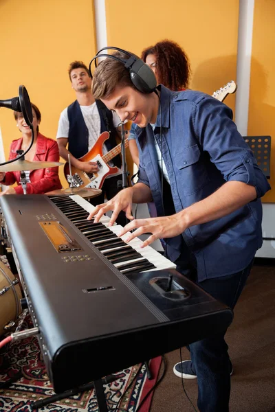 Mężczyzna gra na fortepianie podczas wykonywania w Studio nagrań zespołu — Zdjęcie stockowe