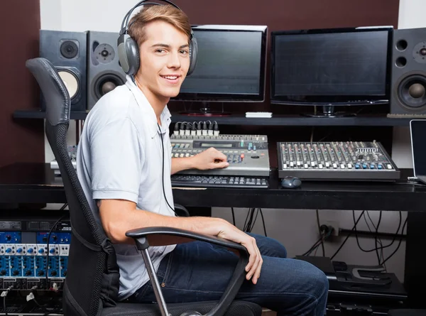 Uomo sorridente che mescola l'audio nello studio di registrazione — Foto Stock