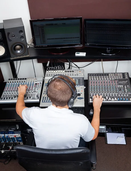 스튜디오에서 오디오를 믹싱 하는 젊은 남자의 뒷 모습 — 스톡 사진