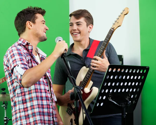 Cantante actuando mientras mira al guitarrista en el estudio de grabación —  Fotos de Stock