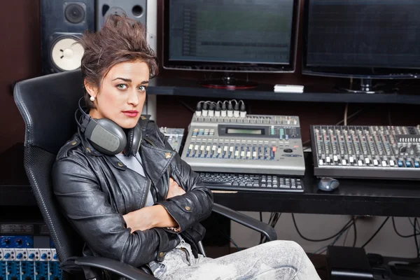 Femme assise avec les bras croisés au bureau de mélange — Photo