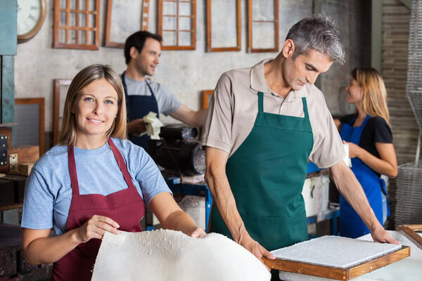 Smiling Woman Making Papers With Colleagues In Factory