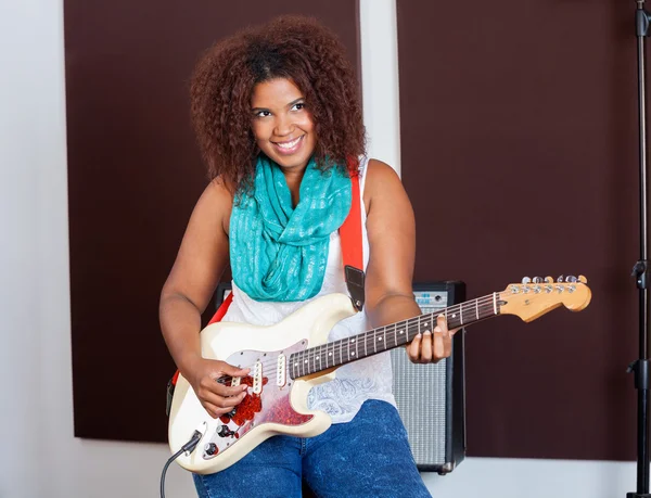 Mulher tocando guitarra em estúdio de gravação — Fotografia de Stock