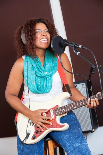 Жінка співачка грає гітару в студії звукозапису — стокове фото