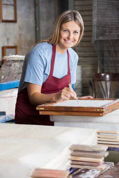 Papel de limpeza de trabalhador sorridente com pinças — Fotografia de Stock