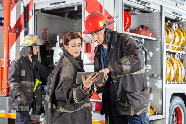 Brandweerlieden met behulp van Tablet PC tegen Truck — Stockfoto