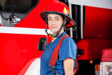Kendinden emin Firewoman kırmızı kask giyiyor portresi