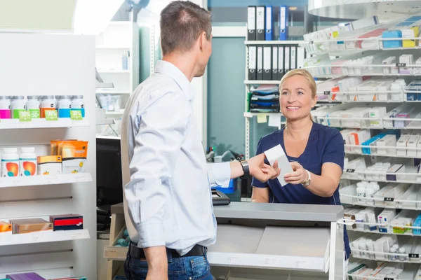 Chemist Giving Product To Customer In Pharmacy — Stock Photo, Image