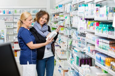 Phar içinde cep telefonu tutan müşteriye ürün gösterilen Yardımcısı