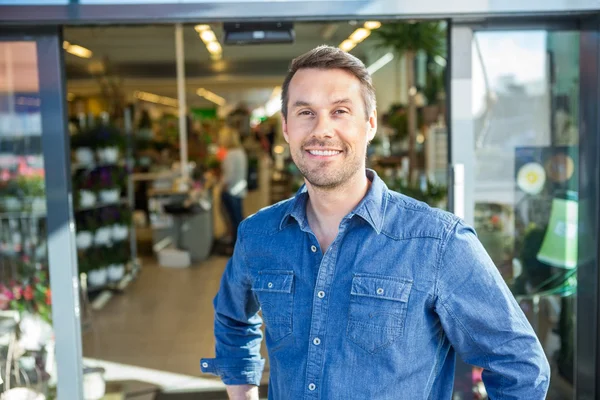 Zelfverzekerde Man permanent buiten bloemenwinkel — Stockfoto