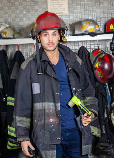 Selbstbewusster Feuerwehrmann in Uniform am Feuerwehrhaus — Stockfoto