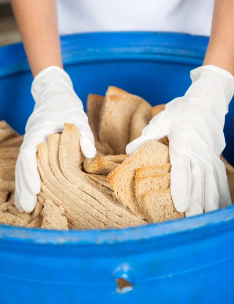 Жінки руки відкидають хлібні відходи в сміттєвому кошику — стокове фото