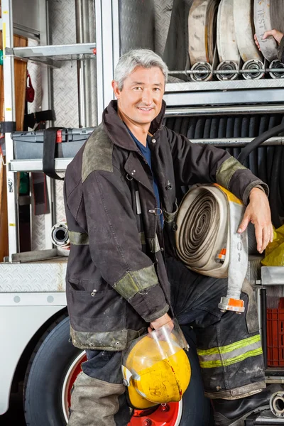 Selbstbewusster Feuerwehrmann steht neben LKW — Stockfoto