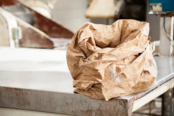 Saco de papel farinha na mesa na padaria — Fotografia de Stock